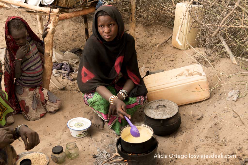 joven fulani yayai preparando mantequilla en el fuego